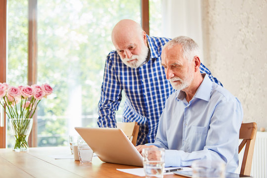 Two seniors using computers in e-learning
