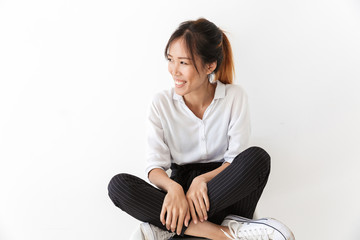 Smiling young asian woman wearing casual outfit sitting