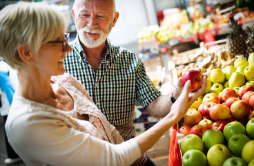 Portrait of beautiful elderly couple in market buing food