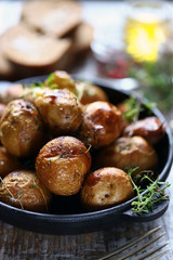 Baked potatoes in a peel in a cast-iron skillet. Rustic potatoes. Selective focus. Macro.