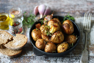 Baked potatoes in a peel in a cast-iron skillet. Rustic potatoes. Selective focus. Macro.