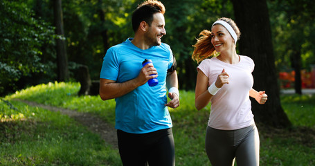 Happy couple jogging and running outdoors in nature