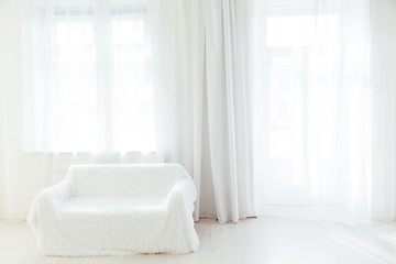 sofa in the interior of a white room with windows