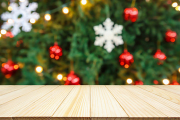 Fototapeta na wymiar Empty wood table top with Abstract blur Christmas tree with decoration bokeh light background for product display