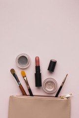 Top view arrangement with make-up products with beauty bag
