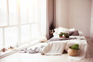 Beautiful light, interior with large bed and window, with Christmas decor. The concept of new year, Christmas, huge