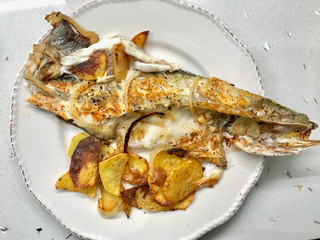 Fillet of Sea Bass Grilled with Potatoes and Onions in Plate.