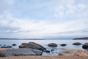 Large stones against the cold Northern lake, long exposure