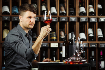 Sommelier looking at red wine glass with beverage
