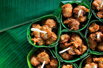 fried fish-paste balls in banana leaves on buffet line