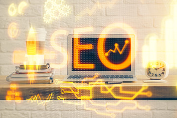 Multi exposure of table with computer and seo drawing hologram. Search optimization concept.