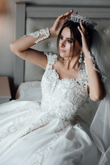 Fototapeta premium Beautiful bride with stylish make up and hair style.Beautiful happy bride corrects the crown. Beauty face.