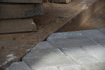 Paving stones in contact with the curb at a construction site is close
