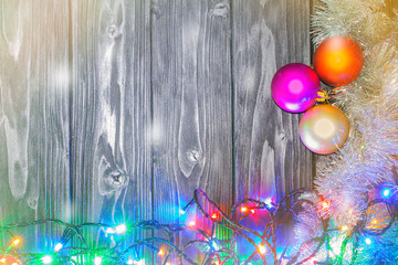Christmas or New Year background. Vintage Christmas tree toy decoration balls and light garland over rustic wooden background, selective focus, copy space.