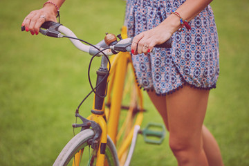 Obraz premium Pretty woman standing with old bicycle outdoors.