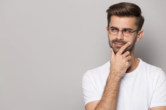 Pensive male in glasses look at copy space making decision