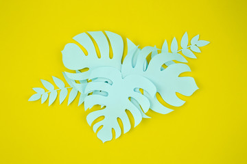 Paper cut style of monstera leaves on yellow background