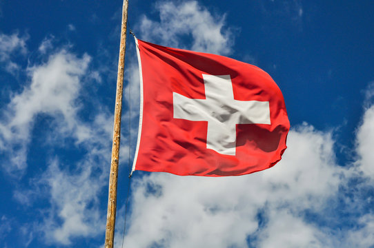 Schweizer Flagge Wind Wolken Fahnenmast Eidgenossen blauer Himmel Hintergurnd Ikone rot wei&szlig; Bund holzmast Berge Alpen Sommer wehen hissen Feiertag nationalit&auml;t Europa Swiss