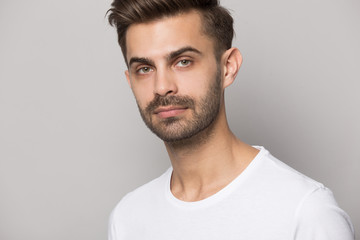 Fototapeta premium Close up of serious caucasian man posing on grey background