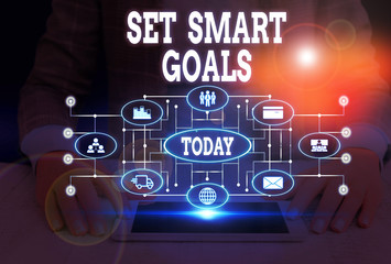 Writing note showing Set Smart Goals. Business concept for giving criteria to guide in the setting of objectives Woman wear formal work suit presenting presentation using smart device