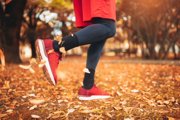 Close up of feet of a runner running in autumn leaves training exercise