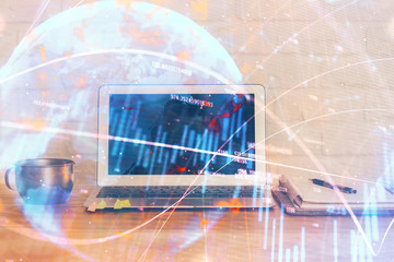 Financial chart drawing and table with computer on background. Multi exposure. Concept of international markets.