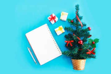 notebook for notes and a green Christmas tree with New Year's decor