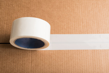 Cardboard box with white adhesive tape with copyspace. Top view