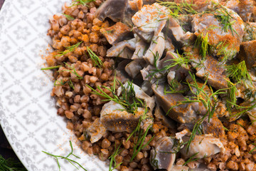 Stewed turkey stomachs with vegetables and buckwheat in a bowl