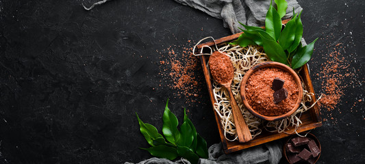 Brown Sea salt with chocolate aroma. On a black stone background. Spa treatments. Top view. Free copy space.