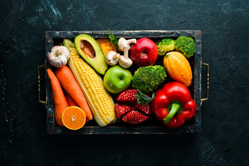 Fresh vegetables and fruits on black stone background. Healthy food. Top view. Free copy space.
