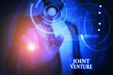 Handwriting text Joint Venture. Conceptual photo Collaboration Arrangement Parties Partnership Team Male human wear formal work suit presenting presentation using smart device