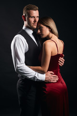 attractve man and woman in fashion stylish clothes express tender feeling while standing over black background. close up portrait, isolated black background, studio shot
