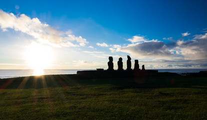 Moais in Ahu Tahai at sunset with sun in the horizon