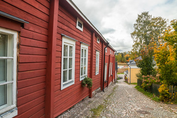 Fototapeta na wymiar Narrow street of Old Porvoo, Finland. Beautiful city autumn landscape with colorful wooden buildings.