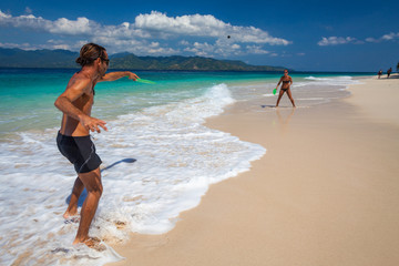 Fototapeta na wymiar Couple play badminton on the tropical beach