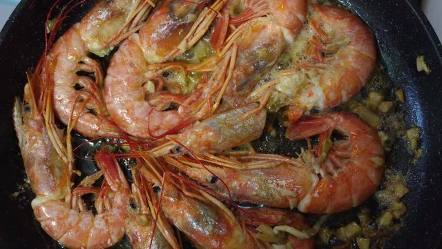 Red prawns fried in a pan with butter and garlic