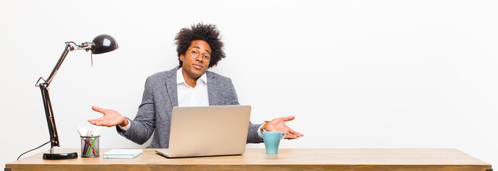 young black businessman feeling puzzled and confused, unsure about the correct answer or decision,...