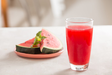 Watermelon juice, watermelon slices and mint leaves.