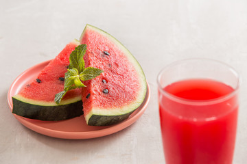 Watermelon juice, watermelon slices and mint leaves.