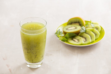Glass of kiwi juice with fresh fruits on wooden table
