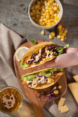 Traditional mexican taco with chicken and vegetables on wooden table. Latin american food.