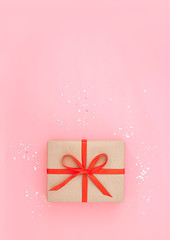 Isolated present or gift box in craft paper with red ribbon bow