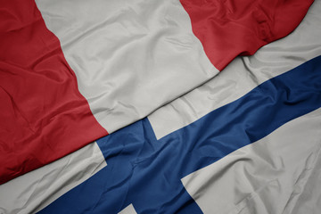 waving colorful flag of finland and national flag of peru.