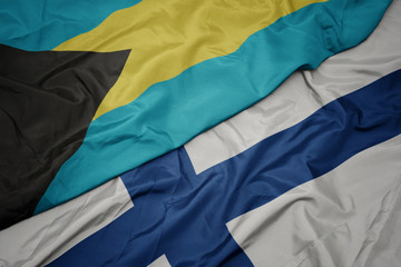 waving colorful flag of finland and national flag of bahamas.