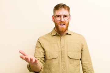 young red head man looking angry, annoyed and frustrated screaming wtf or what‚Äôs wrong with...