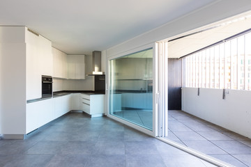 Modern white kitchen in empty apartment with white walls