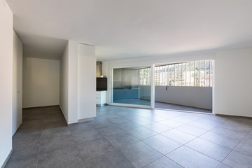 Modern white kitchen in empty apartment with white walls