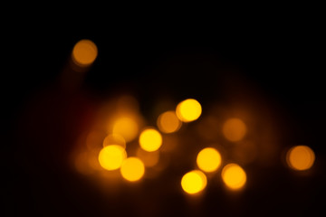 Out of focus yellow and warm lights on black background.