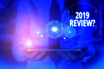 Conceptual hand writing showing 2019 Review Question. Concept meaning remembering past year events main actions or good shows Woman wear work suit presenting presentation smart device